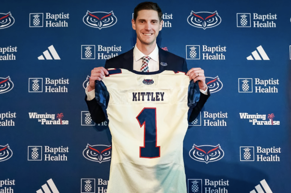 Head coach Zach Kittley posing with a customized jersey with his name on it at his inaugural press conference 